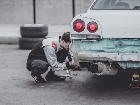 A mechanic working under the hood of a customer's car